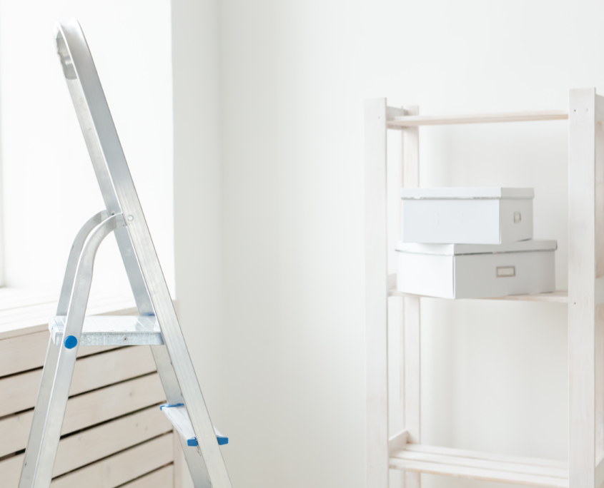 Stepladder and an empty shelf with boxes are in the new living room during the renovation after the move. The concept of housewarming and repair in new housing.